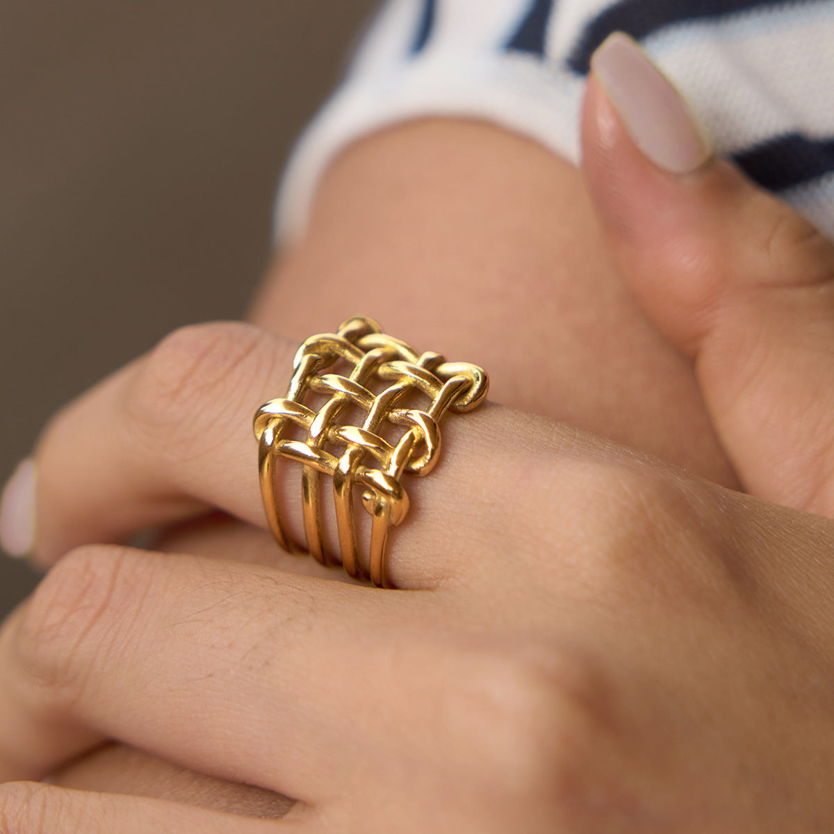 Goudkleurige gevlochten statement ring gedragen aan de hand