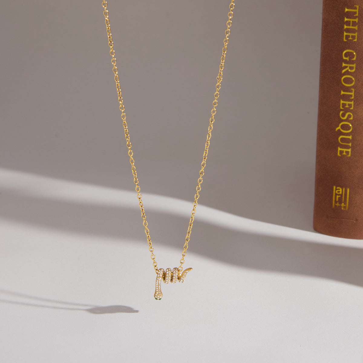 Fijne gouden ketting met slangvormige hanger bezet met zirkonia